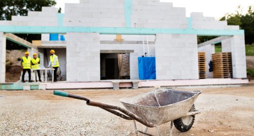 Architects and worker at the construction site. Architect, civil engineer and worker at the construction site. Close up of wheelbarrow.